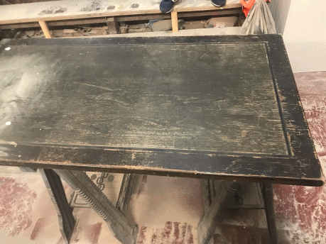 Picture of a wooden table before being fully restored